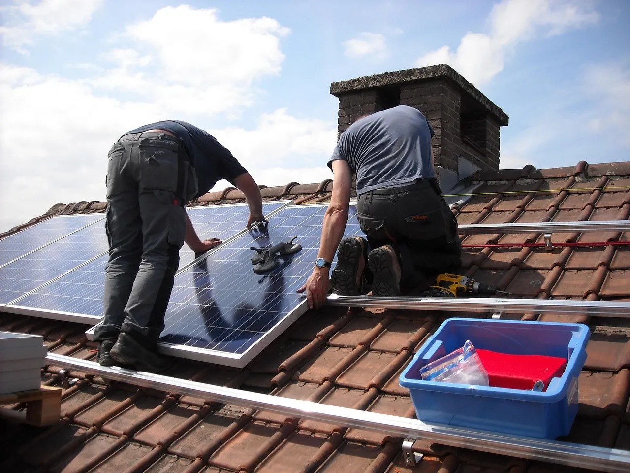 Instaladores colocando paneles solares en el techo de una casa